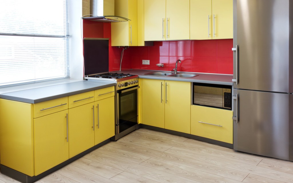 Kitchen with yellow cabinets and red backsplash