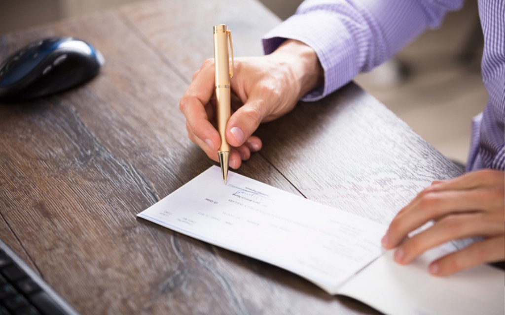 Man signing cheque with a pen