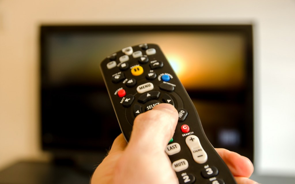 Person holding TV remote control